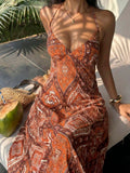 Rust orange paisley halter maxi dress seated front view with coconut and woven bag