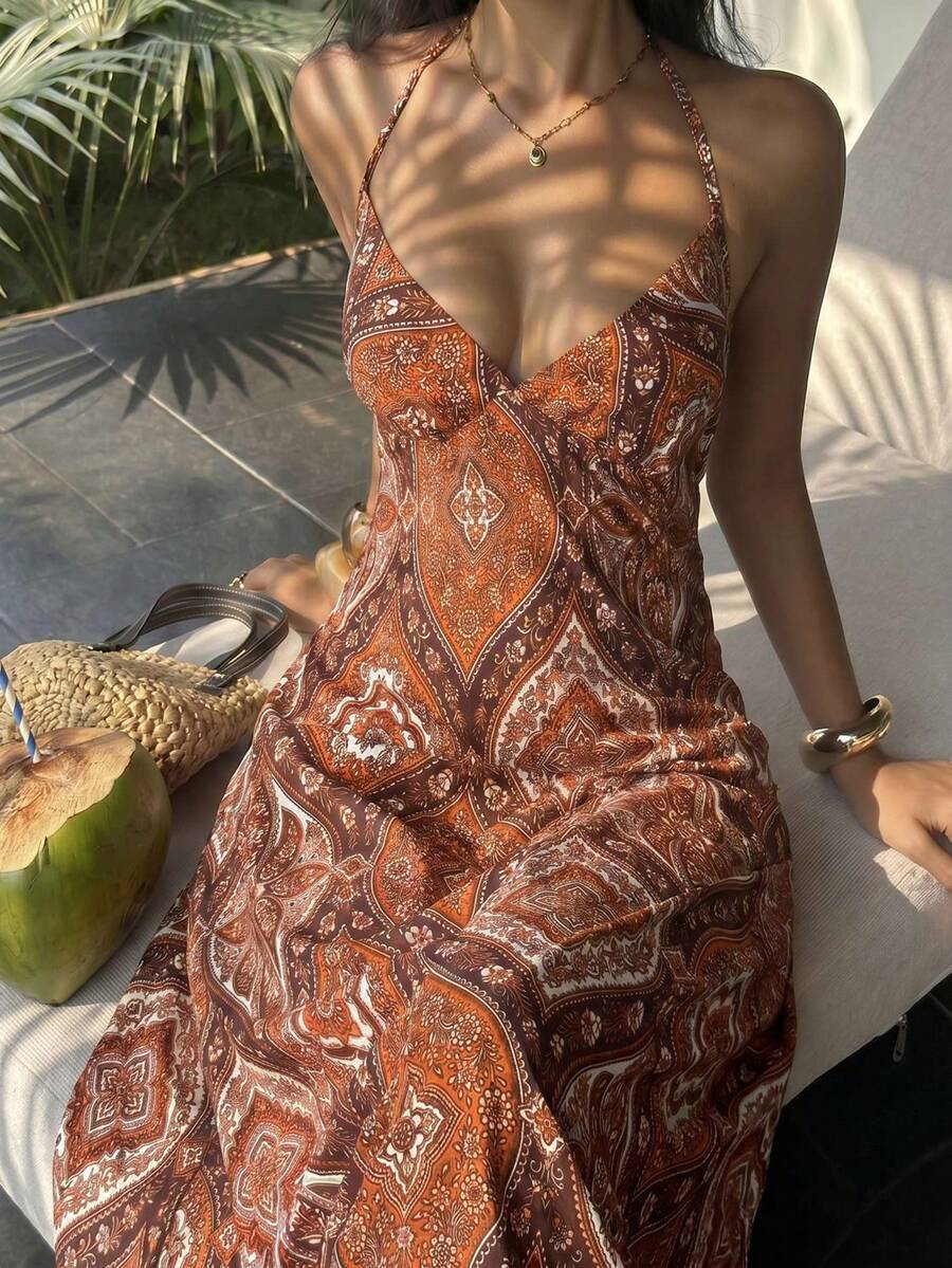 Rust orange paisley halter maxi dress seated front view with coconut and woven bag