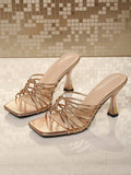 Front product view of champagne metallic slip-on sandals with wrapped rings and sculpted heels