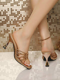 Worn rear side view of champagne metallic slide sandals with flared high heels for evening styling