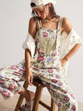 Seated view of floral woven jumpsuit with wide straps and cropped legs