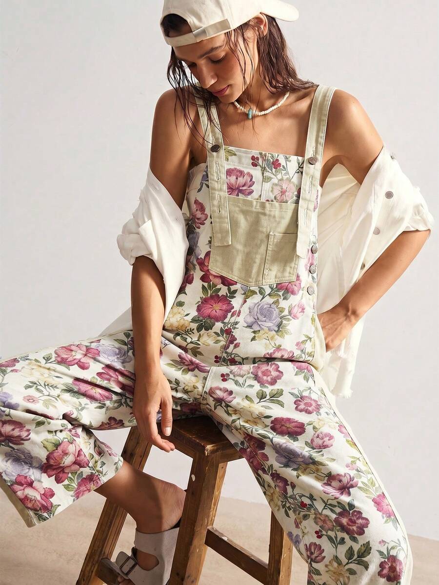 Seated view of floral woven jumpsuit with wide straps and cropped legs