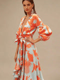 Mid-length front view of coral tropical print maxi dress with deep V-neck and bow belt