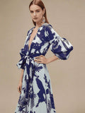 Mid-length view of navy tropical print maxi dress showing kimono sleeves and waist tie