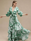 Three-quarter motion view of green tropical print maxi dress with flowing asymmetric ruffles
