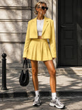 Front view of yellow cropped blazer and pleated mini skirt tailored set