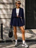 Front view of navy cropped blazer and high-waisted pleated mini skirt outfit