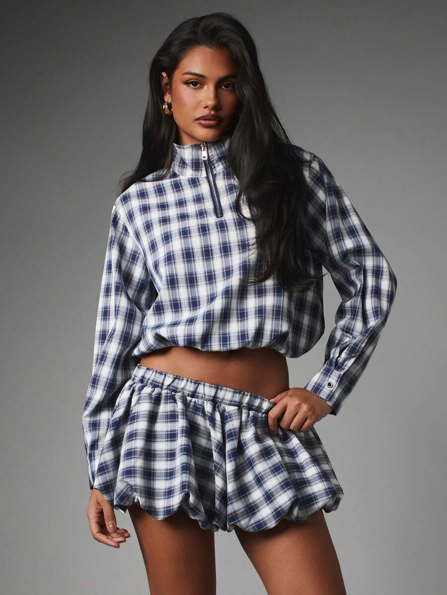 Front view of plaid two piece set with cropped half zip top and bubble mini skirt