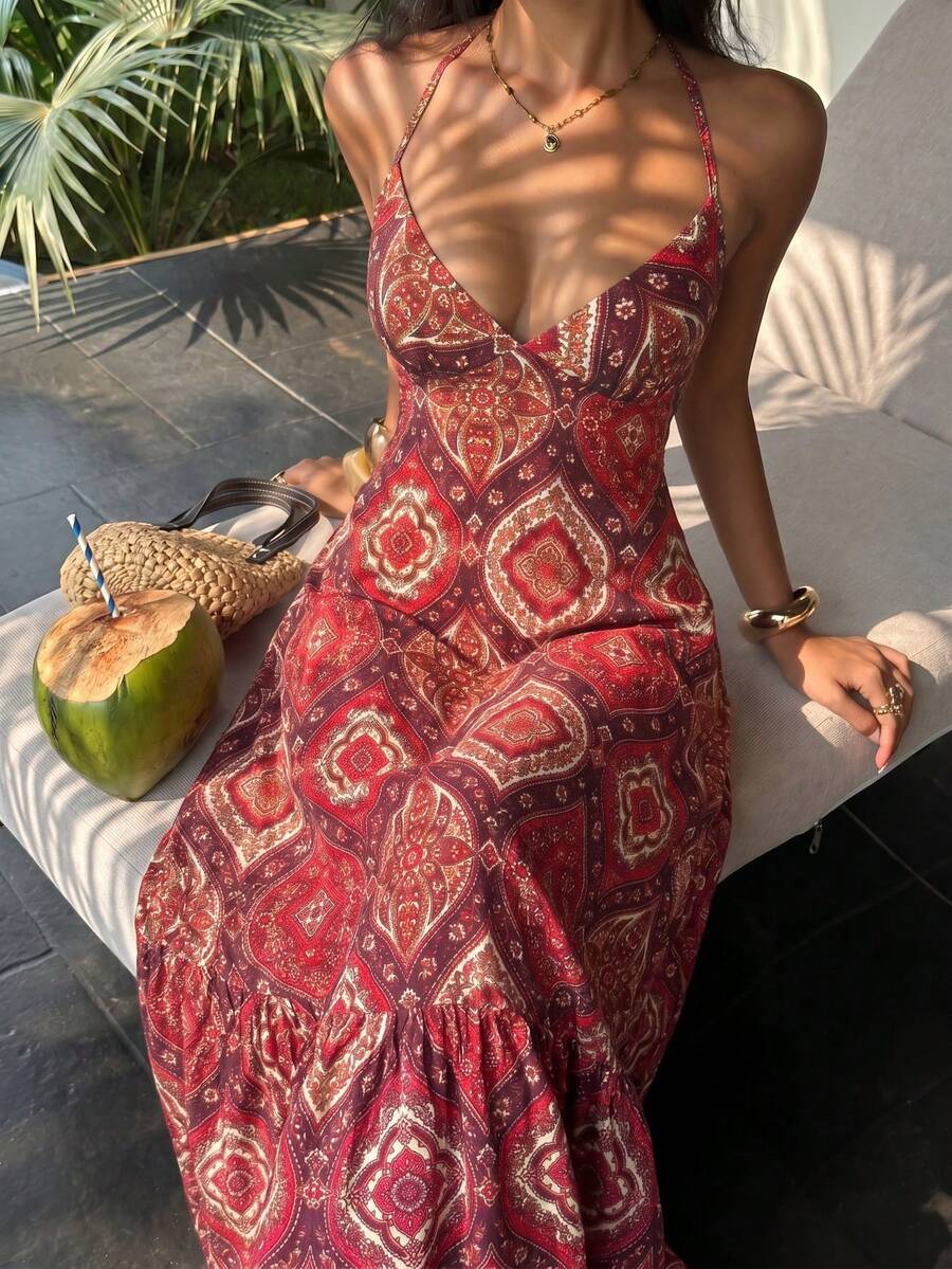 Red paisley halter maxi dress seated front view with coconut and woven bag