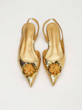 Symmetrical front view of gold embellished slingback flats with sharp pointed toes