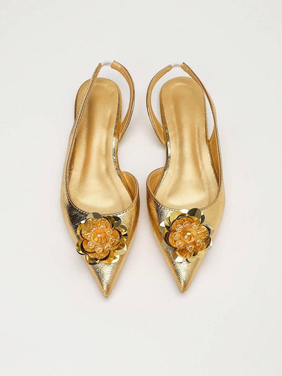 Symmetrical front view of gold embellished slingback flats with sharp pointed toes