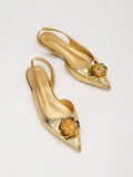 Diagonal top view of gold pointed toe slingback flats showing padded insoles and straps