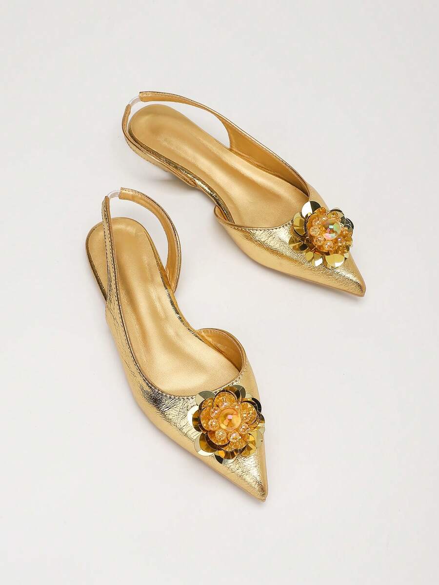 Diagonal top view of gold pointed toe slingback flats showing padded insoles and straps
