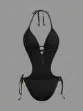 Back studio view of black halter cutout one-piece swimsuit with open back and tie details for beach party styling