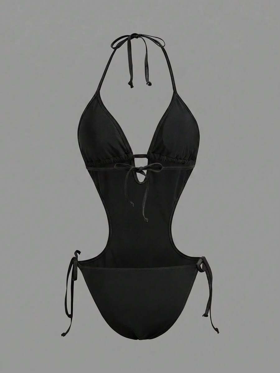 Back studio view of black halter cutout one-piece swimsuit with open back and tie details for beach party styling