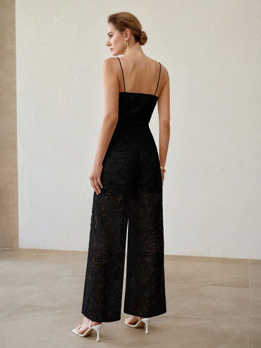 Rear three-quarter view of black spaghetti-strap jumpsuit with semi-sheer floral wide legs