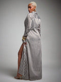 Rear three-quarter view of brown striped long-sleeve maxi shirt dress with flowing skirt and side slit