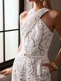 Close-up of ivory floral jumpsuit showing crossover halter neck, raised roses, belt, and pocket