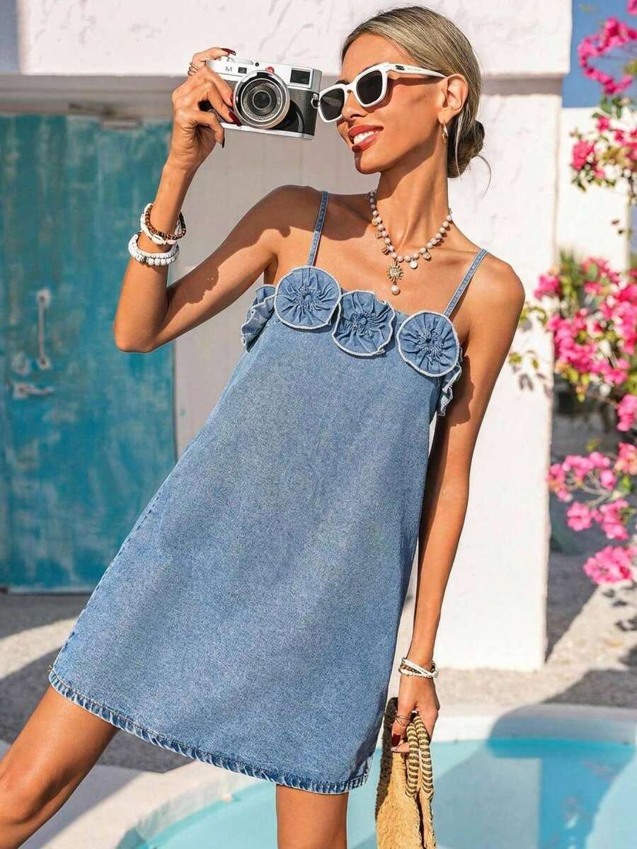 Front view of light-wash denim mini dress with rosette neckline appliqués