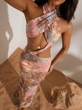 Detail of crossed bust and shell charm on tropical print maxi dress