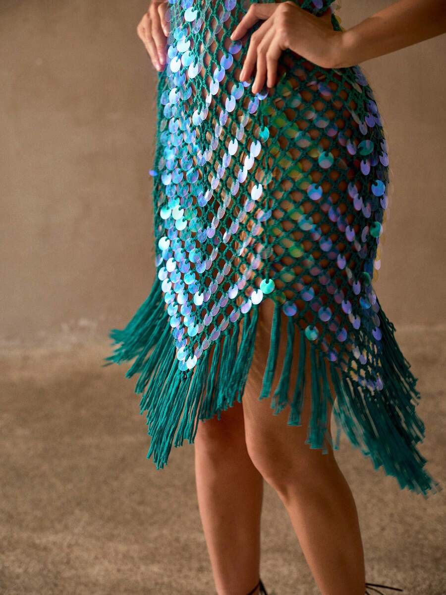 Front three-quarter view of teal crochet swim cover-up with iridescent sequins and fringe hem