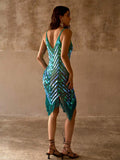 Back view of teal crochet swim cover-up with deep V back, iridescent discs, and fringe hem