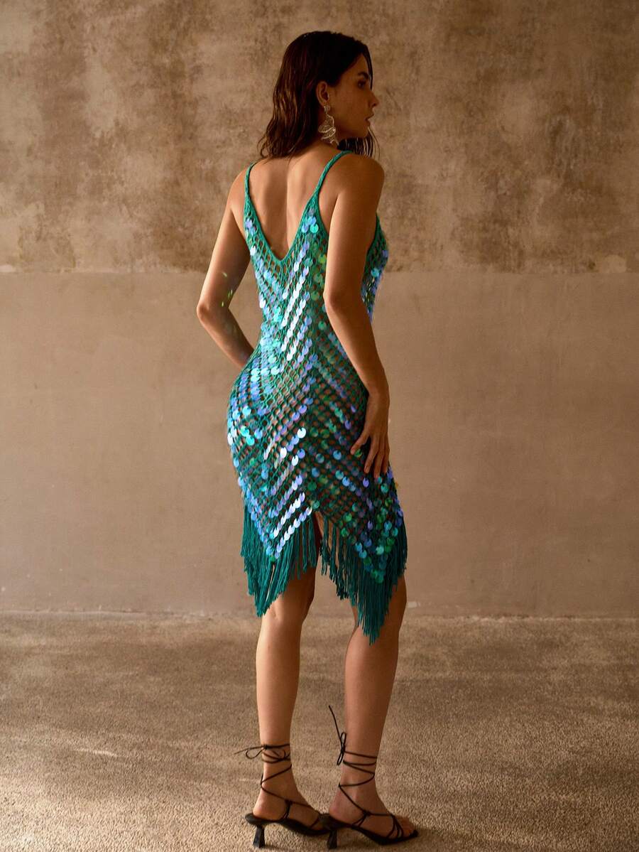 Back view of teal crochet swim cover-up with deep V back, iridescent discs, and fringe hem