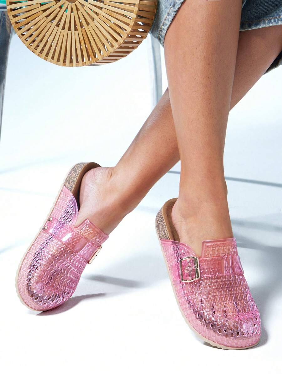 Pink fisherman-style jelly clogs worn with a vacation outfit
