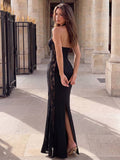 Rear three-quarter view of black backless maxi dress with halter neckline and lace panels