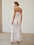 Rear three-quarter view of white floral jumpsuit with spaghetti straps and flowing wide legs