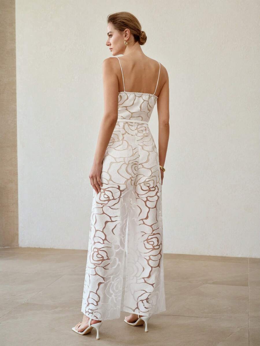 Rear three-quarter view of white floral jumpsuit with spaghetti straps and flowing wide legs
