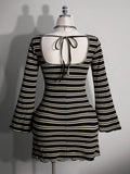 Back view of black striped mini dress showing open back and tie detail