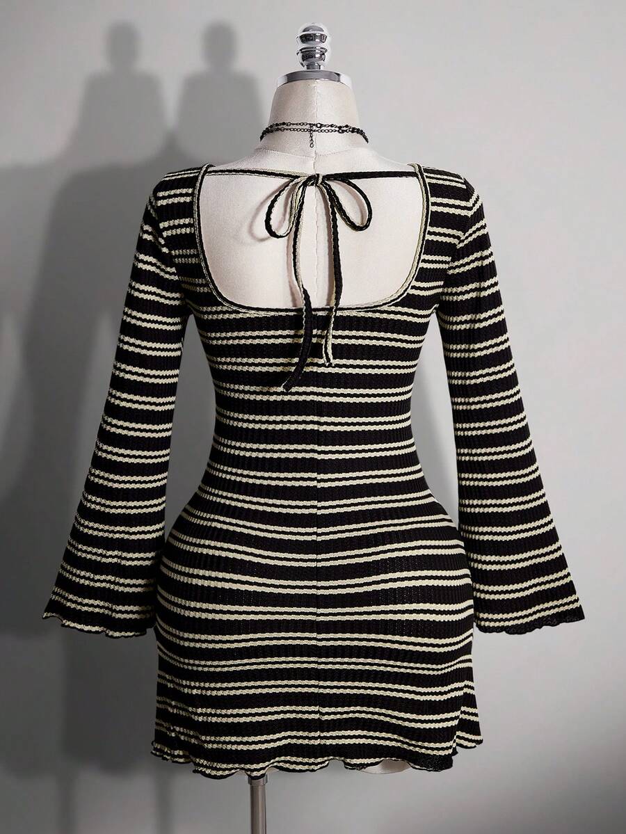 Back view of black striped mini dress showing open back and tie detail