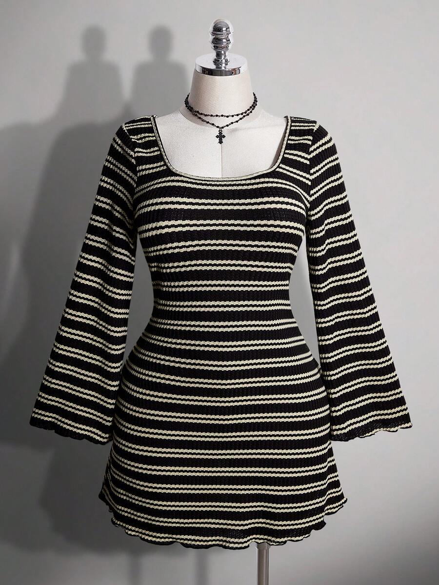 Front view of black and cream striped A-line mini dress with fitted waist
