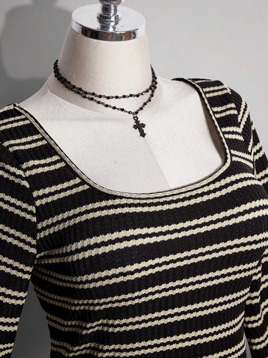 Close-up of square neckline and narrow cream stripes on black knit dress