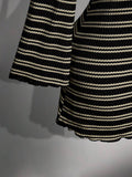 Close-up of flared bell sleeve and striped knit texture