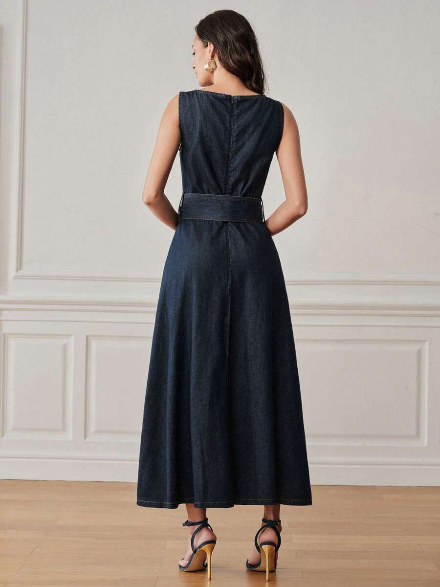 Full front view of dark indigo belted denim maxi dress styled with clutch and heels