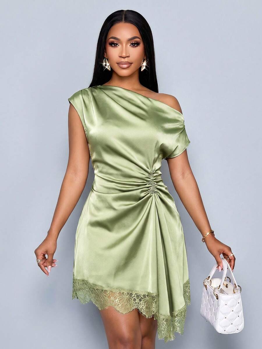 Front three-quarter view of sage green satin one-shoulder mini dress with ruched waist and lace-trim hem