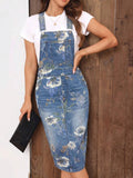 Close front view of floral denim pinafore midi dress with adjustable buckles and hip pockets