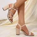 Side profile of beige suedette party sandals with rhinestone band and block heel
