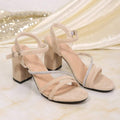 Product view of beige open toe sandals showing ankle buckles and chunky high heels