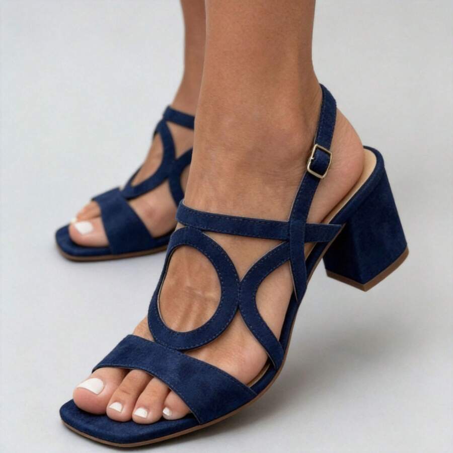 Three-quarter view of navy blue open toe buckle strap block heel sandals on model