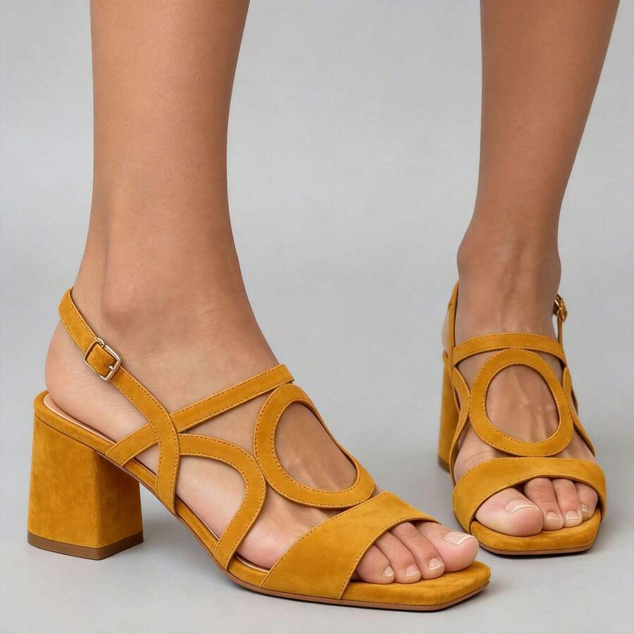 Three-quarter view of mustard yellow strappy square toe block heel sandals on model