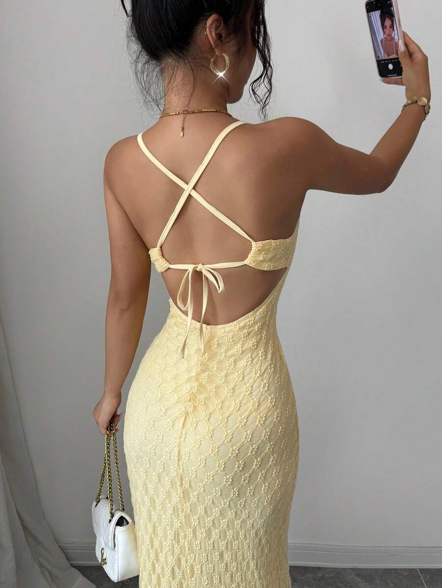Back close-up of light-yellow maxi gown with crossed straps and tie bow
