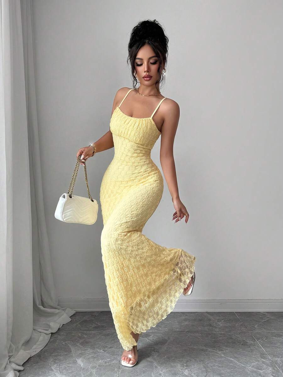 Three-quarter view of light-yellow mermaid gown showing flared openwork hem