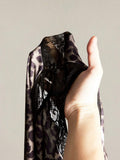 Close-up of semi-sheer leopard knit fabric and black lace trim
