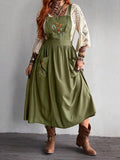 Full front view of army green embroidered A-line dress styled over a crochet top