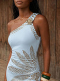 Close view of aqua blue palm print maxi dress with gold floral shoulder accent