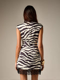 Back view of zebra-print mini dress showing center zipper and scalloped lace hem