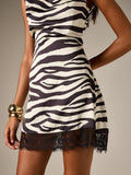 Close-up of zebra stripes and scalloped black lace hem on satin-look mini dress